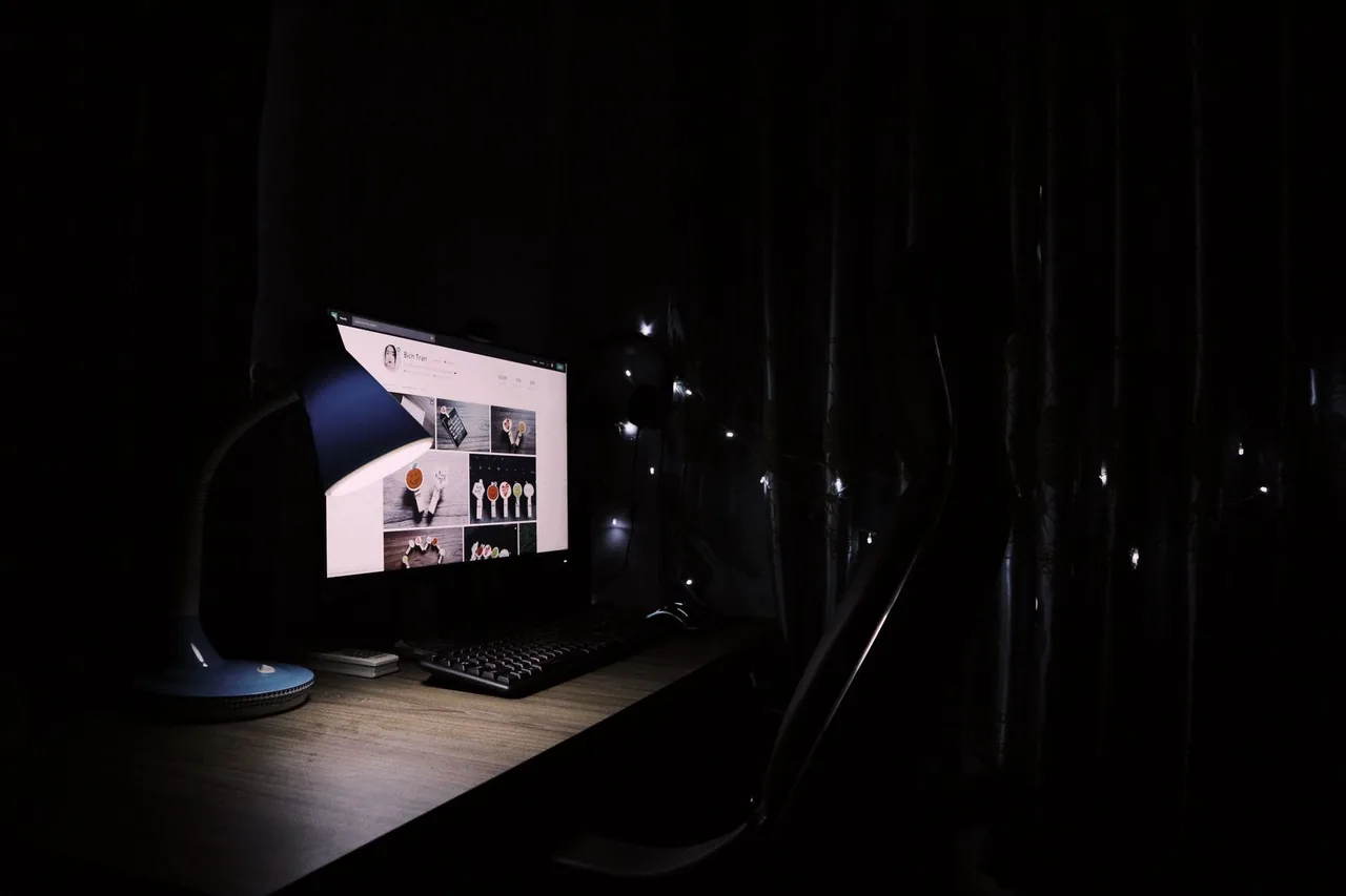 A monitor glowing in a dark room, the setting where blacks that look gray on a monitor are most obvious
