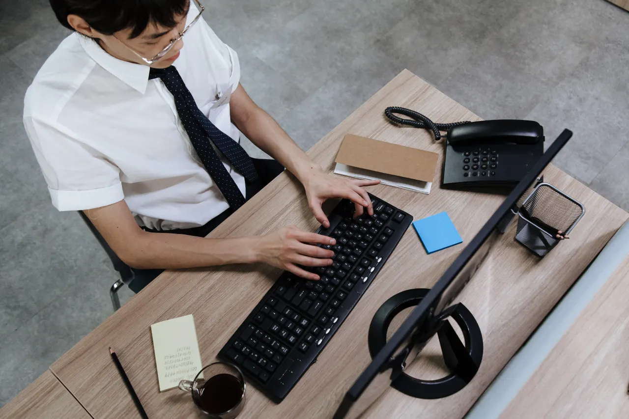 A person at a desk typing on a slim wireless keyboard, the setup where Bluetooth keyboard lag shows up most