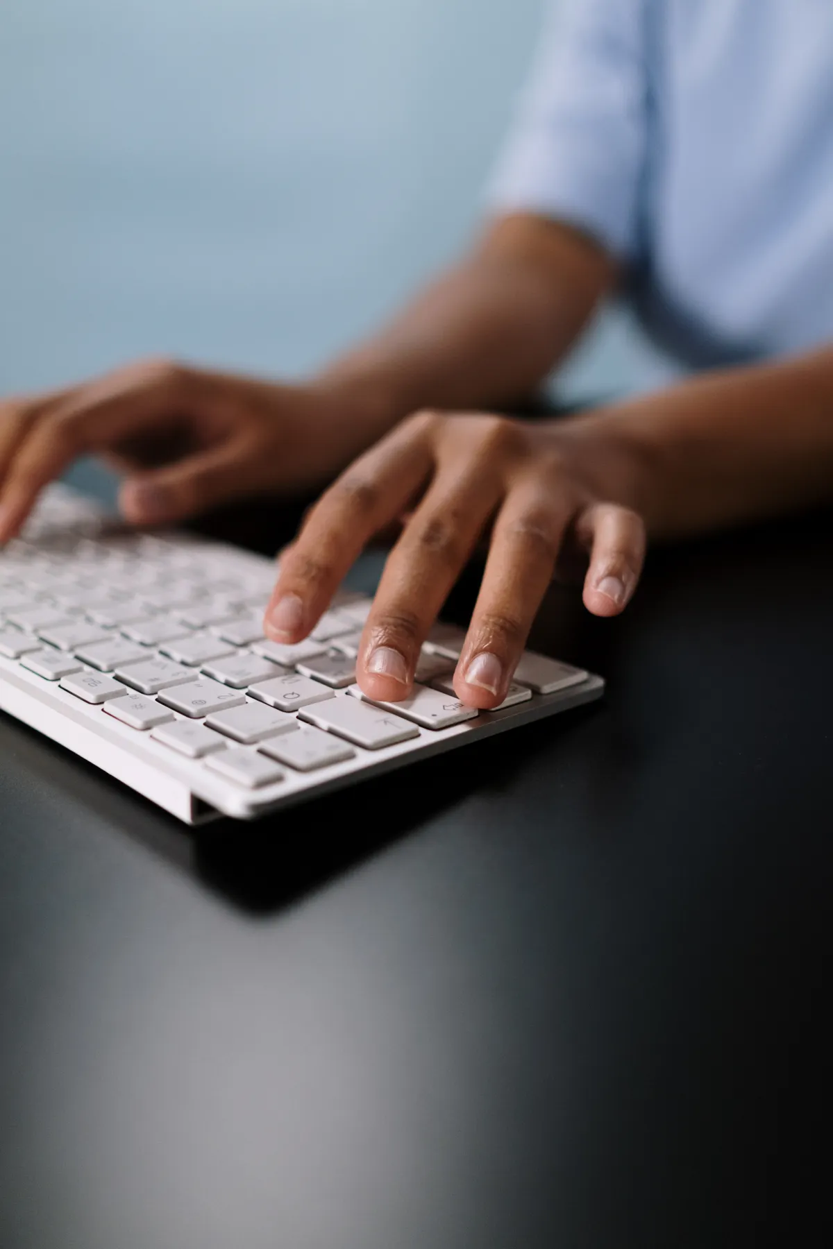 Hands typing on a slim white wireless keyboard while measuring input latency in the browser