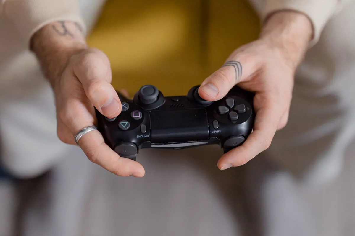 Close-up of hands gripping a black PlayStation controller while deciding which polling rate to use