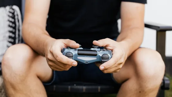 A seated gamer holding a Sony controller in both hands, about to run a controller polling rate test