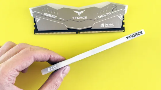 Hand holding a DDR5 memory module next to a second DDR5 RGB stick on a yellow background