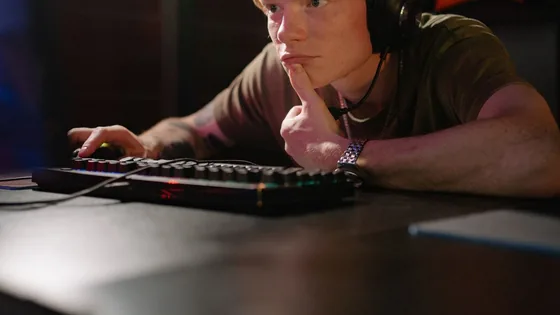 Focused gamer in a headset reacting at a PC, checking whether their reaction time is good for gaming