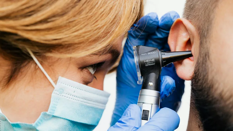 Doctor checking ear health with an otoscope