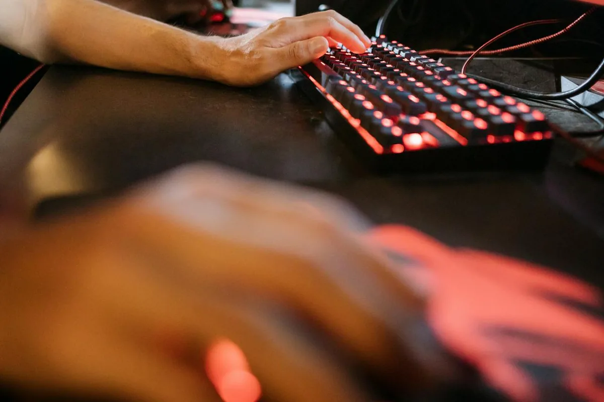 Tangan menggunakan keyboard dan mouse saat membandingkan DPI dan sensitivitas