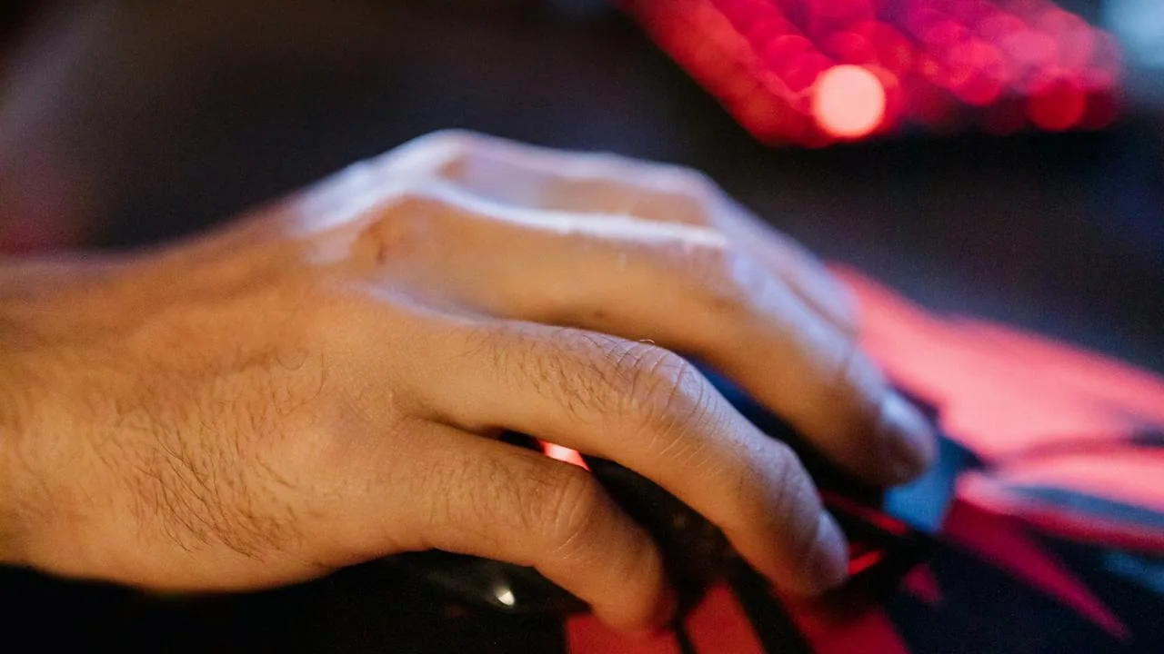 A hand resting on a gaming mouse on a mousepad while checking mouse DPI