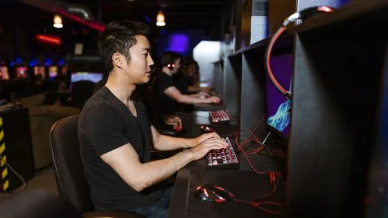 Focused PC gamer at desktop monitors in a gaming venue