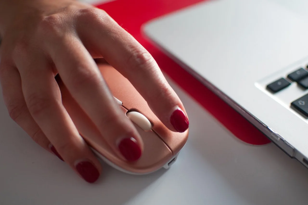 Gamer mid-match with a tensed hand on the mouse, the posture jitter clicking relies on