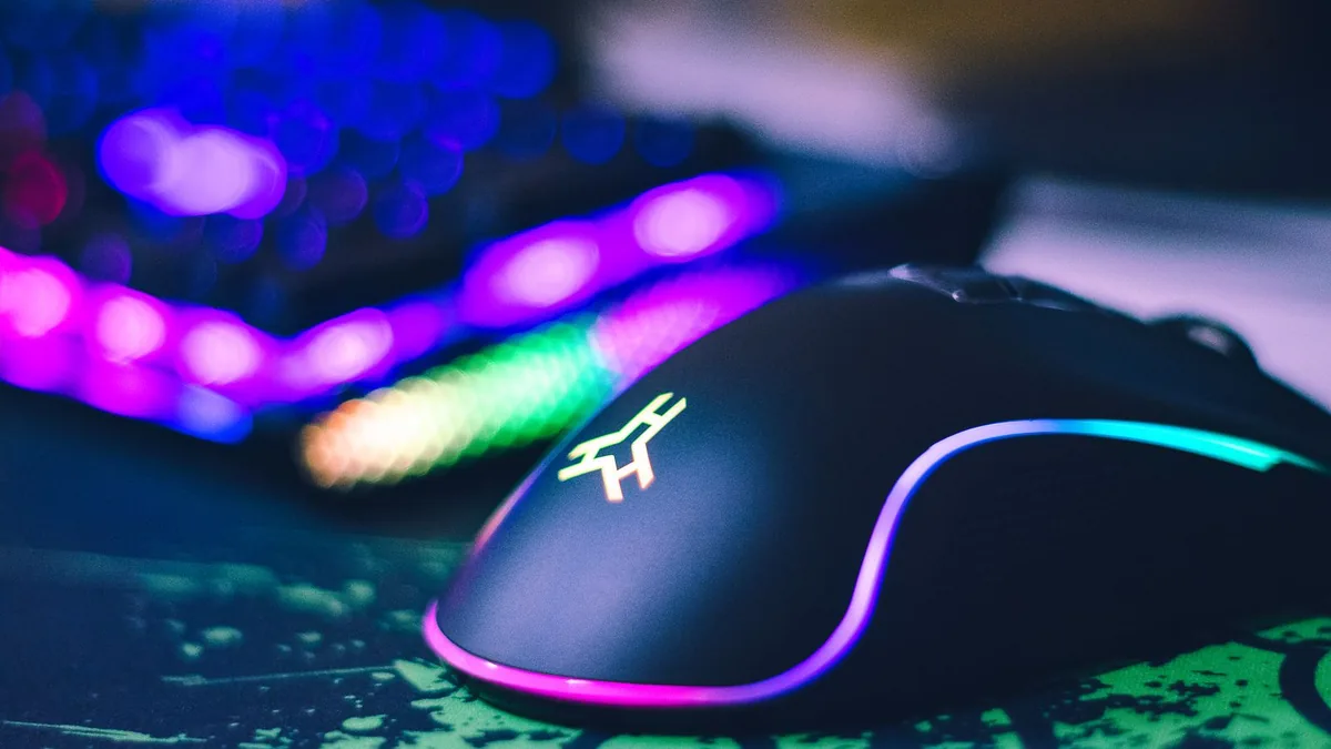 Gamer hand gripping a wired gaming mouse with fingers on the buttons, ready to jitter click or butterfly click