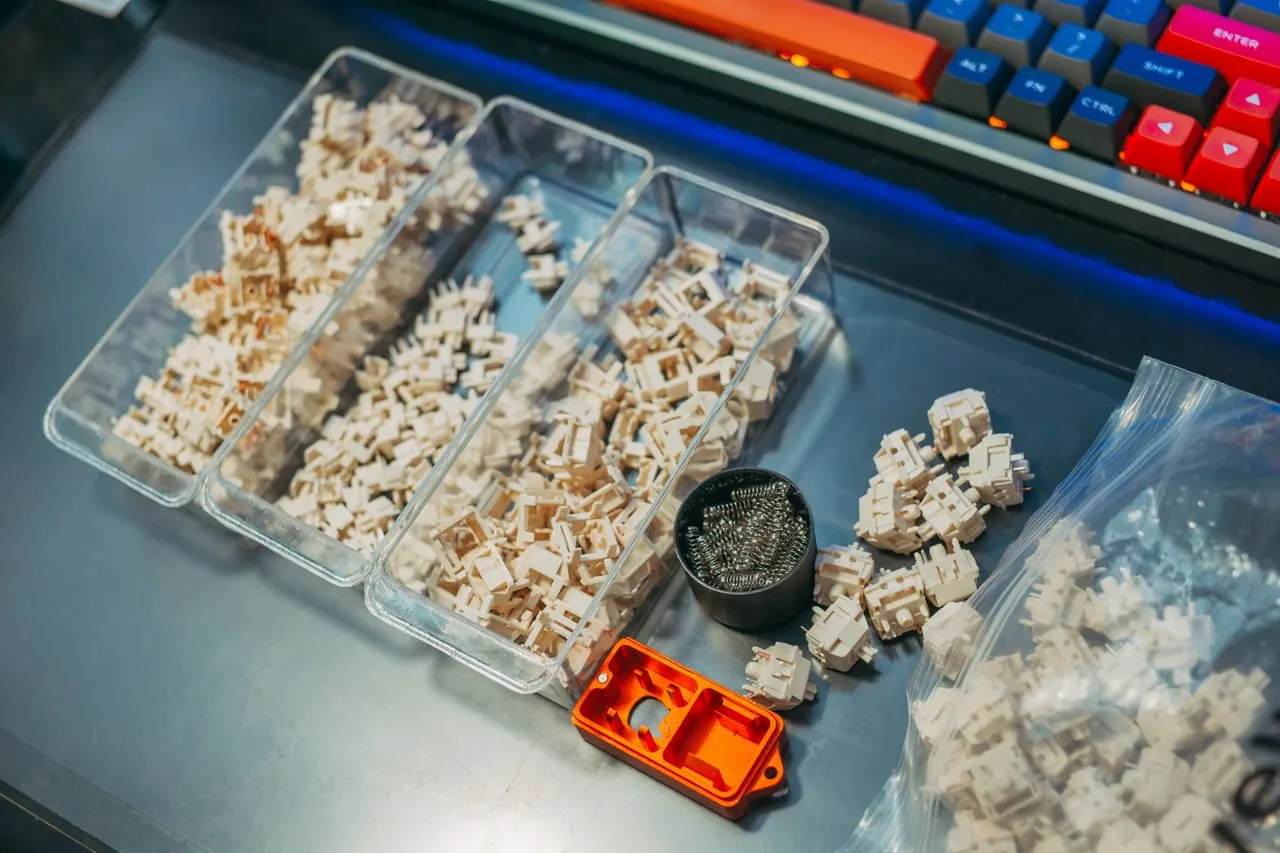 Mechanical keyboard switches and springs on a desk — parts used to fix key chatter