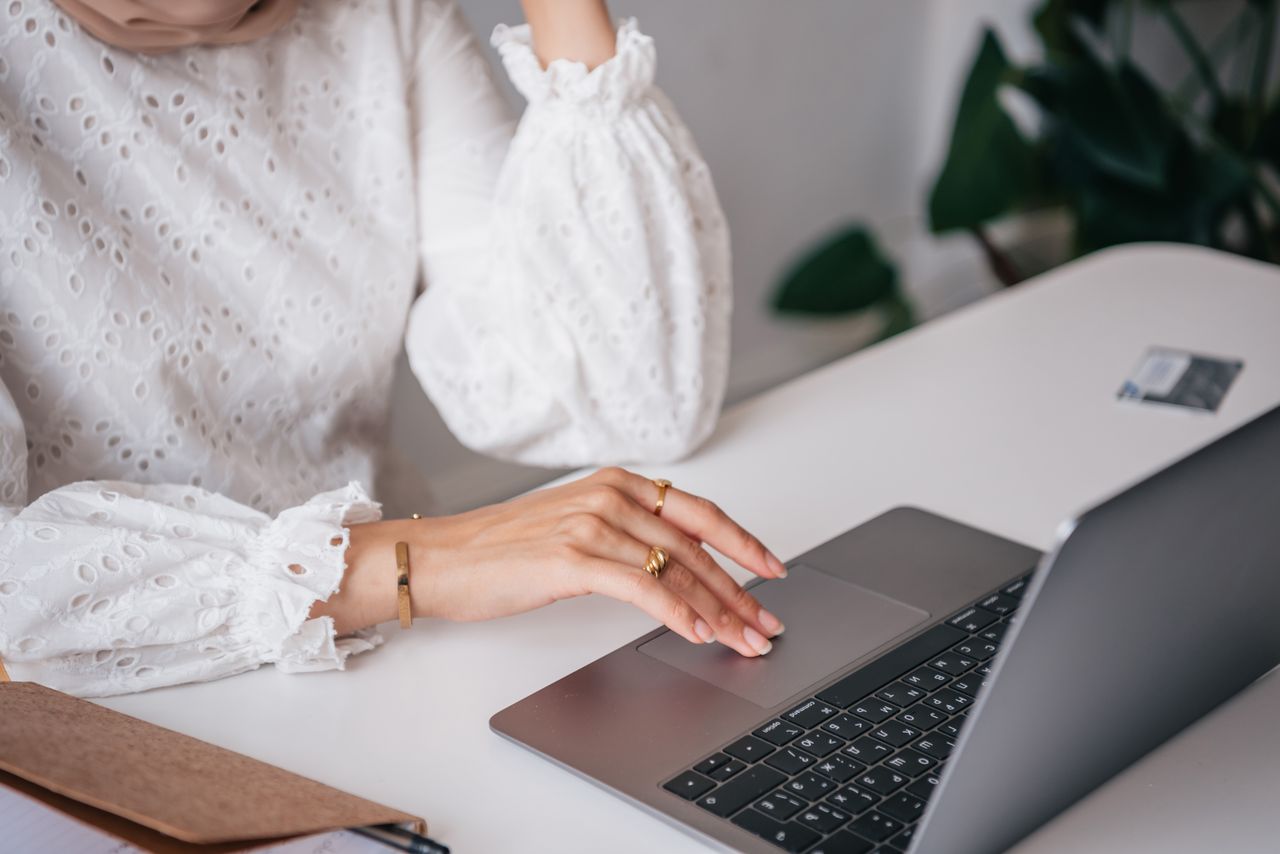 Hand using the touchpad on a laptop at a desk