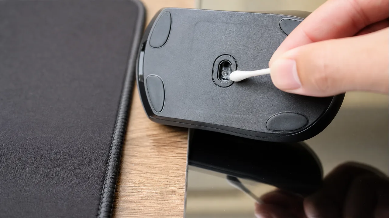 Cleaning the optical mouse sensor beside a matte mousepad and glossy surface