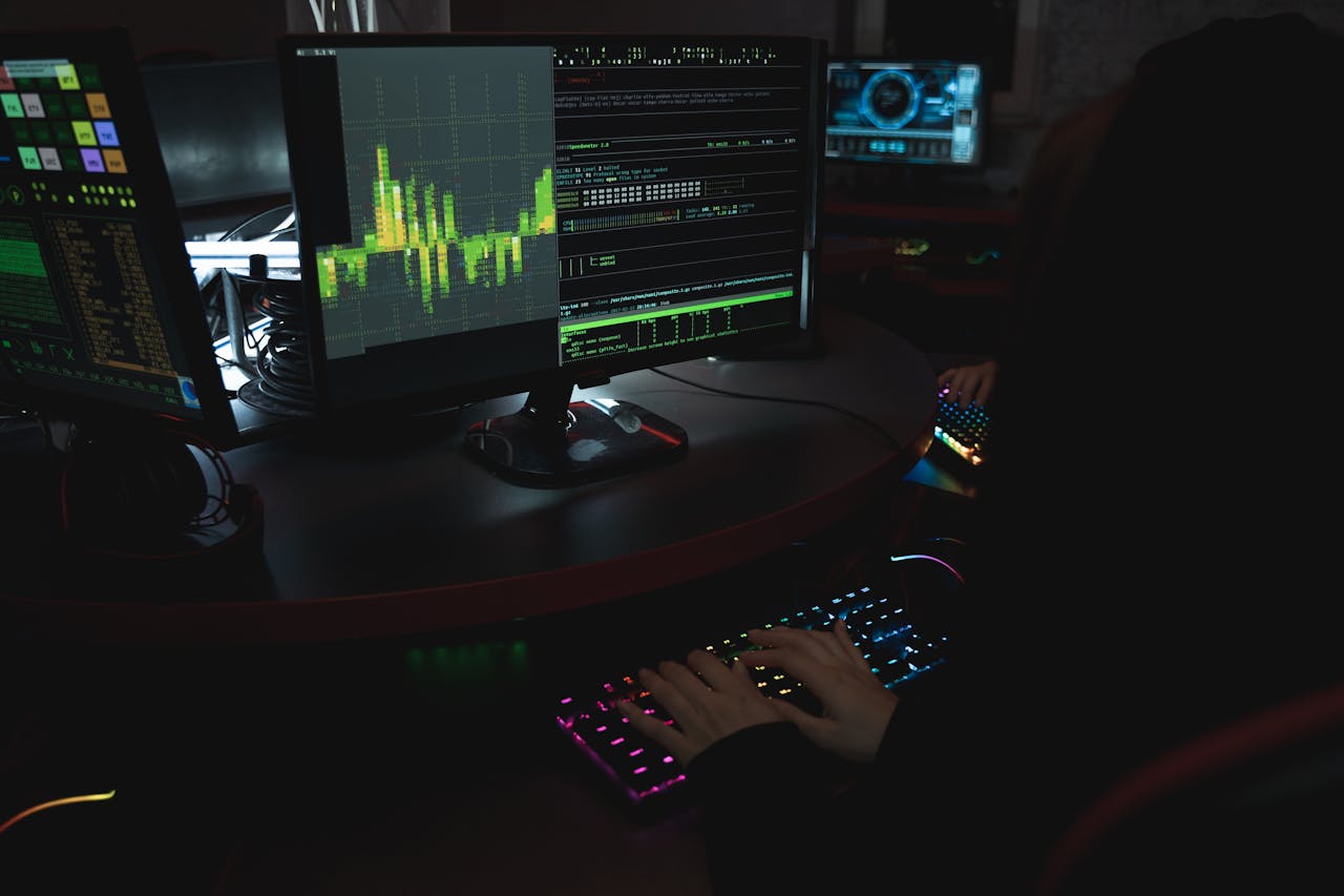 Cybersecurity analyst typing on a colourful mechanical keyboard surrounded by monitors showing code — WebRTC IP leak discovery in action