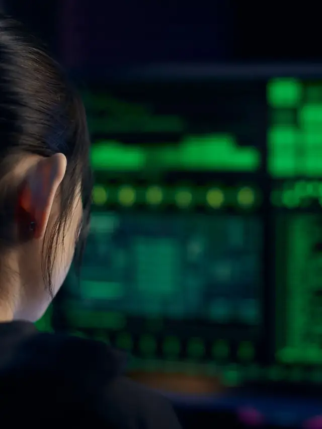 Woman concentrating on a dark glowing computer screen