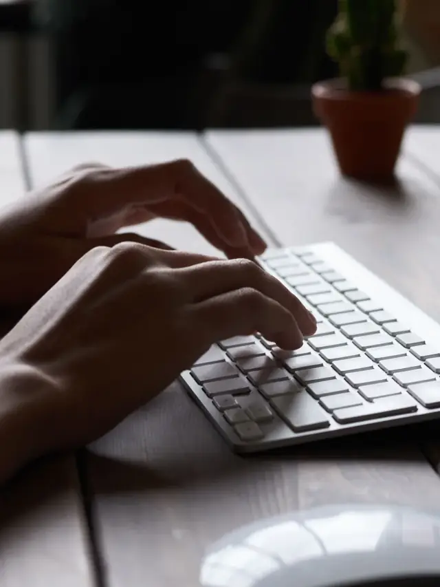 Person making repeated taps on a separate computer keyboard