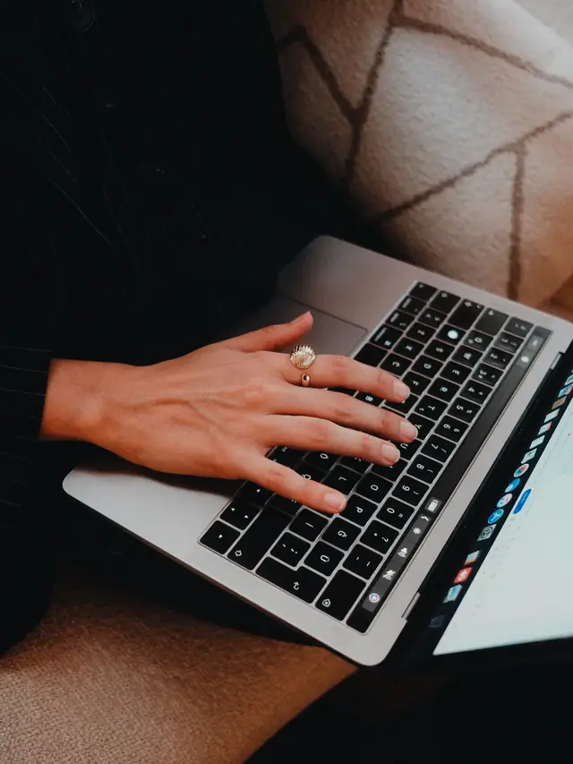 Close view of one hand typing on a laptop keyboard