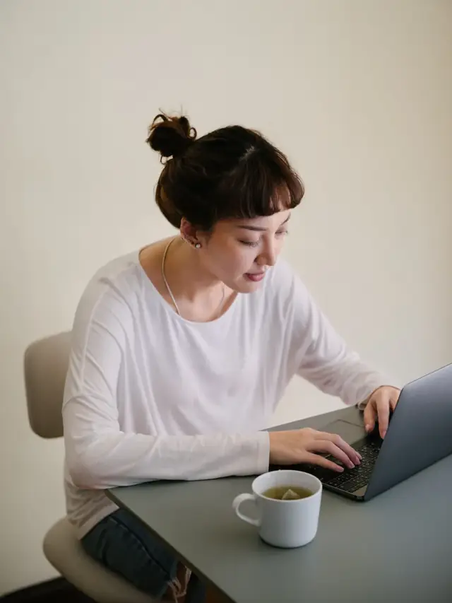 Pensive woman reviewing a typing problem on a laptop