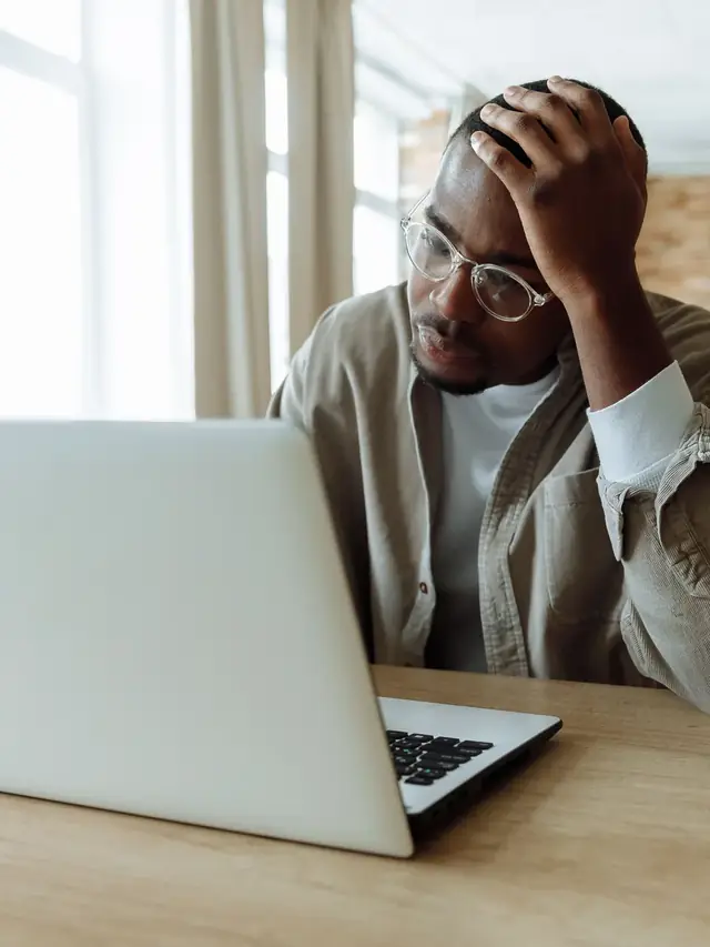 Frustrated man investigating a problem on a laptop