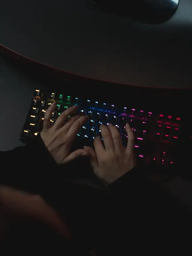 Person actively typing on a colorful mechanical keyboard