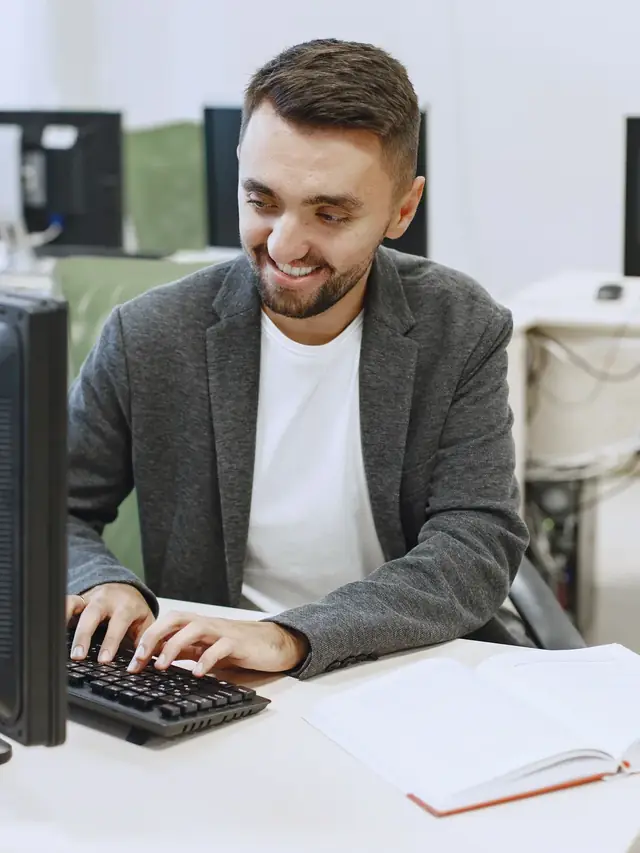 Smiling man reacting while typing on a computer keyboard