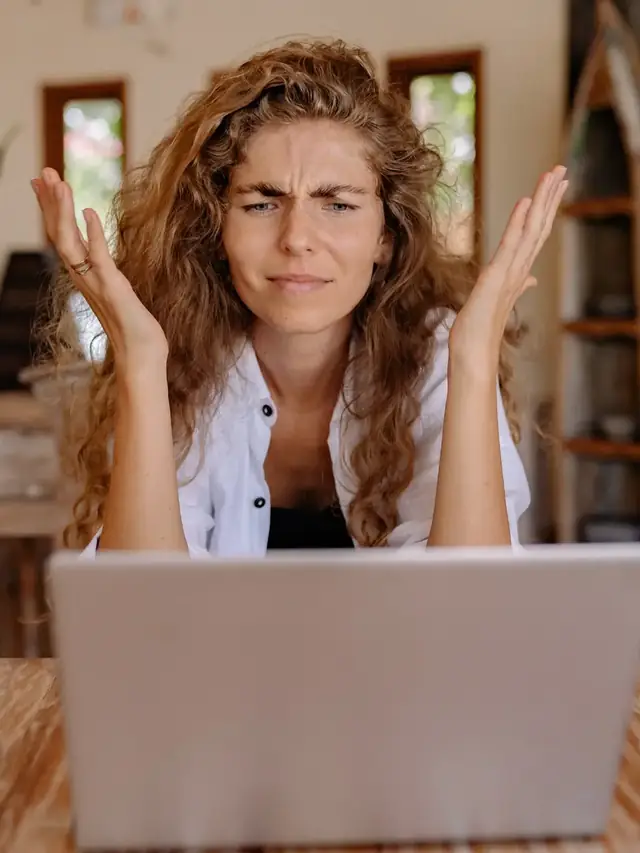 Puzzled woman checking a laptop for a settings problem
