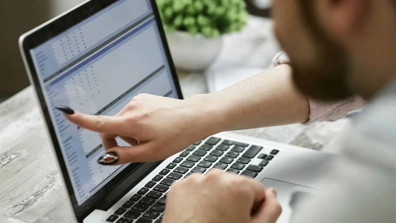 Two website operators reviewing an unexpected analytics traffic spike on a laptop