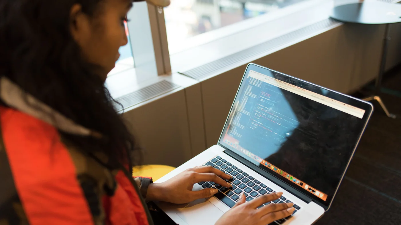 Developer pressing a laptop keyboard while working with code and keyboard shortcuts