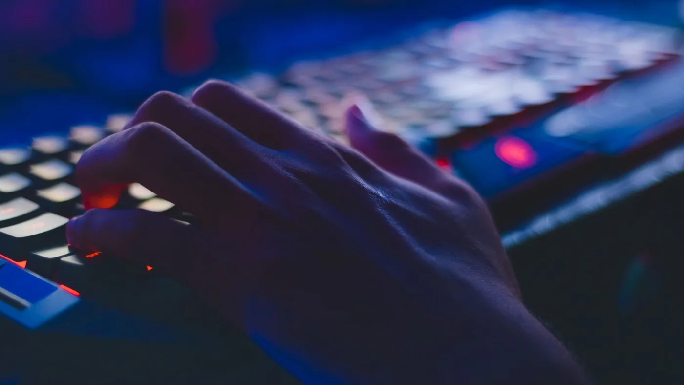 Person pressing the spacebar on a keyboard during an online spacebar test